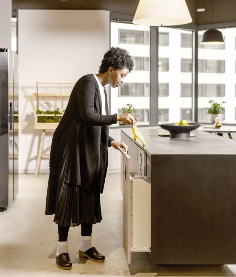 woman standing by the kitchen countertop in her home